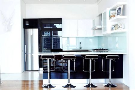 Узкий холодильник серебристого цвета на кухне